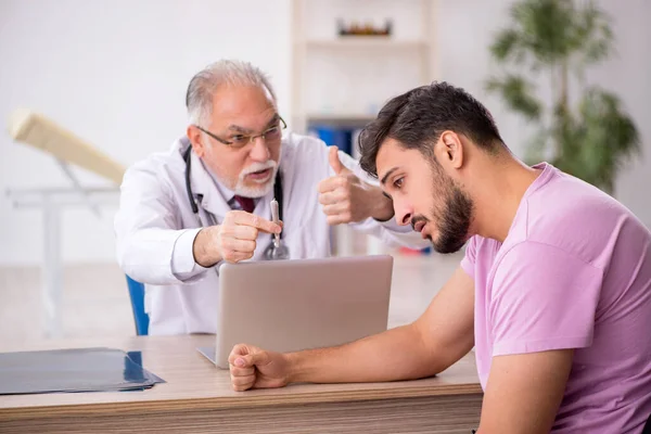 Genç Hasta Yaşlı Erkek Doktoru Ziyaret Ediyor — Stok fotoğraf