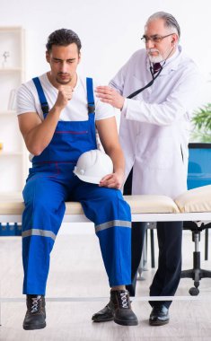 Genç erkek müteahhit yaşlı doktoru ziyaret ediyor.