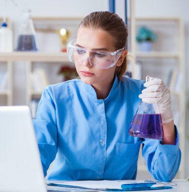 Laboratuvarda bir deney yürüten kadın bilim adamı.