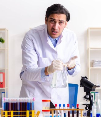 Laboratuvarda çalışan genç erkek kimyager.