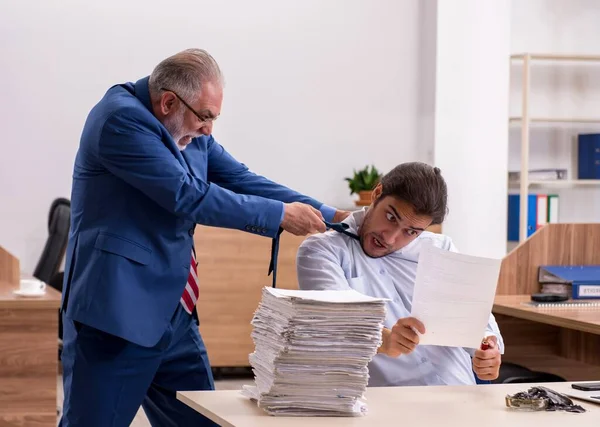男性従業員と彼の古い上司は職場で論文を燃焼 — ストック写真