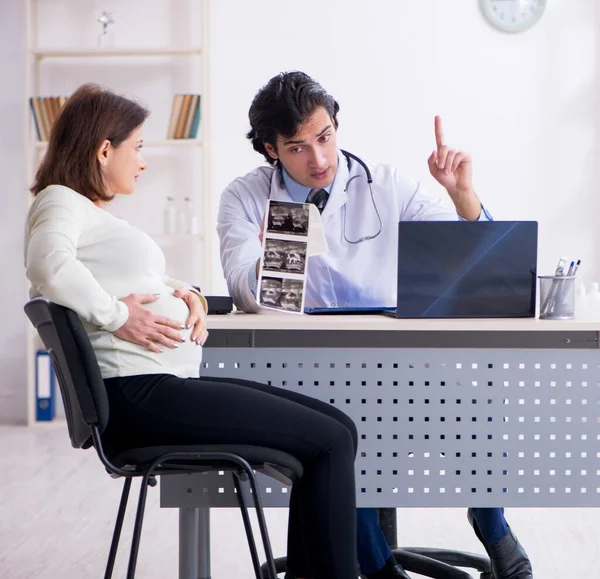 Old Pregnant Woman Visiting Young Male Doctor — Stockfoto
