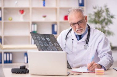 Hastanede çalışan yaşlı bir erkek radyoloji uzmanı.