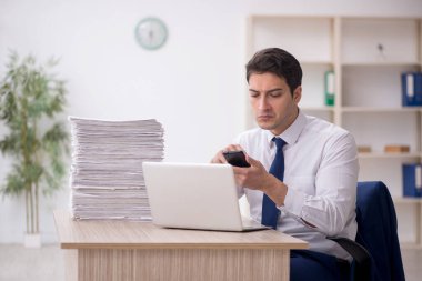 Young employee and too much work at workplace