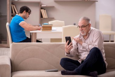Young student and his grandfather at home