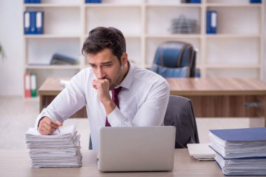 Genç işadamı işyerinde oturuyor.