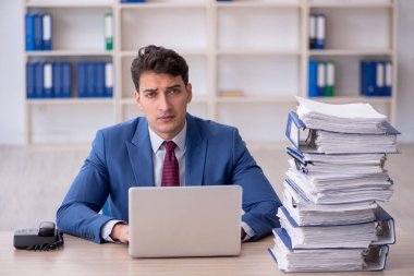 Young employee and too much work at workplace