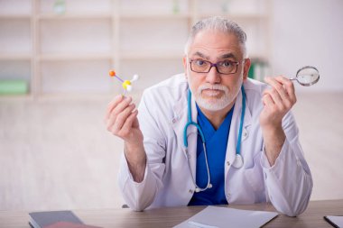 Old doctor sitting at the hospital
