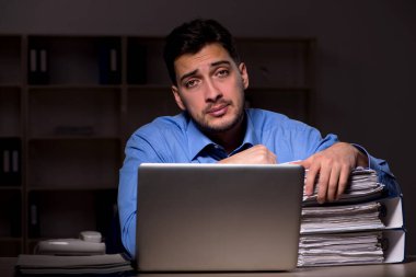 Young employee working late at workplace