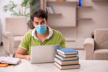Genç öğrenci salgın sırasında evde sınavlara hazırlanıyor.