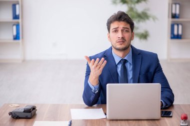 Genç bir çalışan ve ofiste çok fazla iş var.