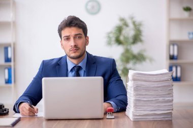 Genç bir çalışan ve ofiste çok fazla iş var.