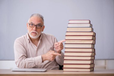 Old teacher sitting in the classroom