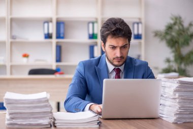Young employee and too much work at workplace