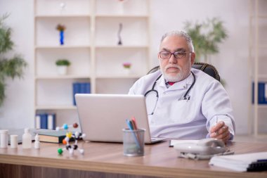 Teletıp konseptinde yaşlı bir doktor.