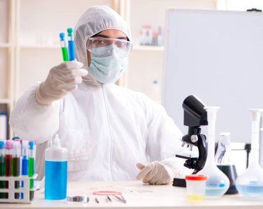 Laboratuvarda çalışan genç yakışıklı kimyager.