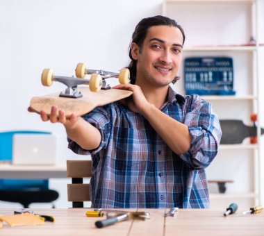 Atölyede kaykay tamir eden adam.