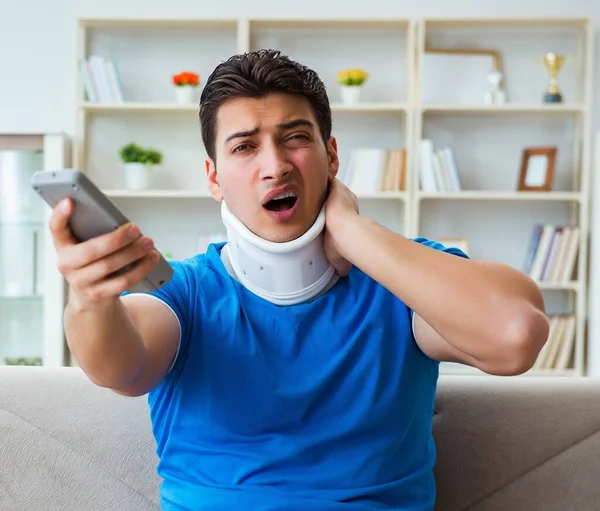 The man with neck injury watching football soccer at home