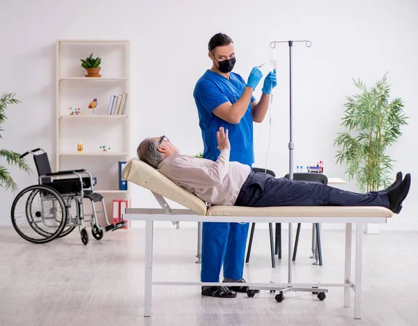 Gammal Patient Besöker Ung Läkare För Intravenös Behandling — Stockfoto