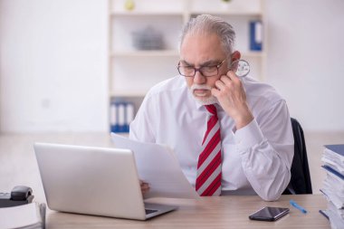 Ofisteki aşırı işten memnun olmayan eski bir işadamı.