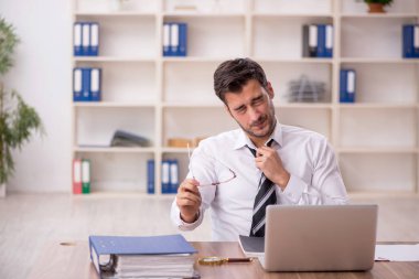 Genç işadamı işyerinde oturuyor.