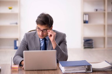 Genç işadamı işyerinde oturuyor.