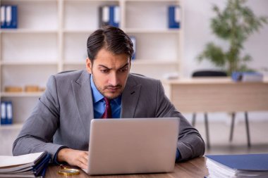 Genç işadamı işyerinde oturuyor.