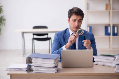 Genç işadamı ve işyerinde çok fazla iş var.
