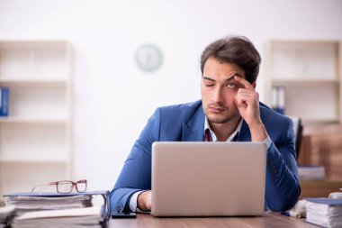 Genç işadamı işyerinde aşırı çalışmaktan memnun değil.