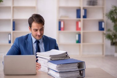 Genç işadamı ve ofiste çok fazla iş var.