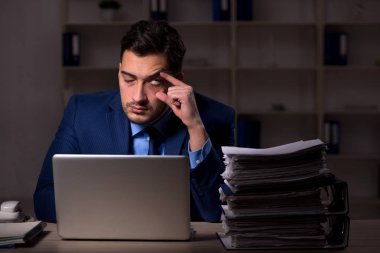 Young employee working late at workplace