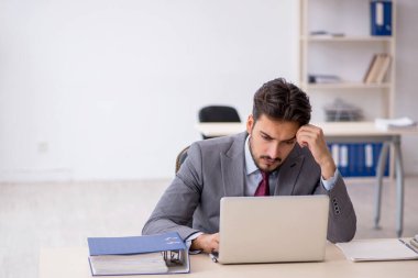 Genç işadamı işyerinde oturuyor.