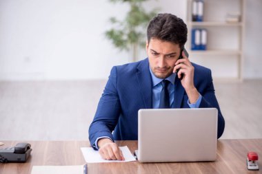 Genç bir çalışan ve ofiste çok fazla iş var.