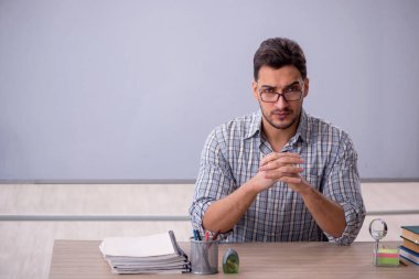 Beyaz tahtanın önünde genç öğretmen.