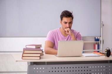 Sınıfta sınava hazırlanan genç bir öğrenci.