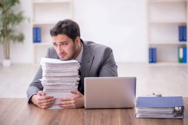 Genç bir çalışan ve ofiste çok fazla iş var.