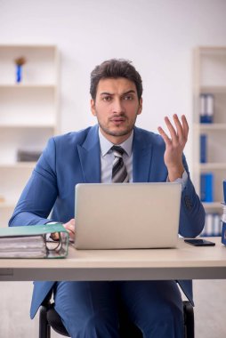 Genç işadamı ve işyerinde çok fazla iş var.