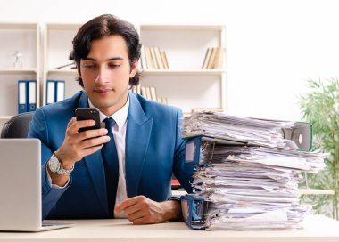 Genç, yakışıklı, meşgul çalışan ofiste oturuyor.