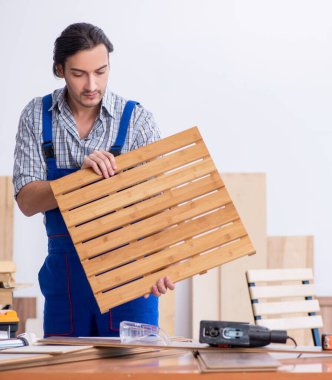 İçeride çalışan genç erkek marangoz.