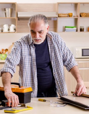 Mutfakta çalışan yaşlı müteahhit.