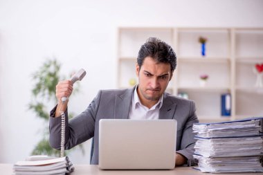 Genç işadamı ve ofiste çok fazla iş var.