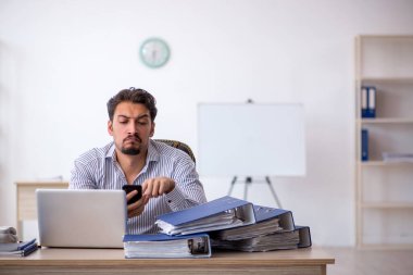 Genç işadamı ve ofiste çok fazla iş var.