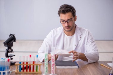 Young chemist in front of white board