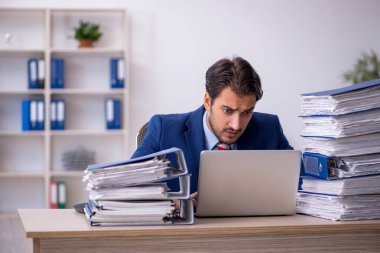 Genç işadamı ve ofiste çok fazla iş var.