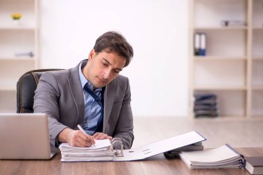 Genç işadamı işyerinde oturuyor.