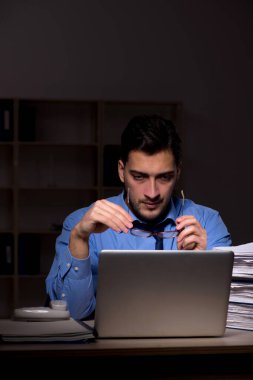 Young employee working late at workplace