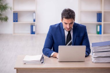 Genç işadamı ve işyerinde çok fazla iş var.