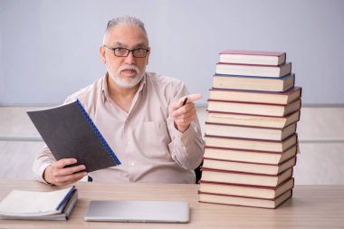 Old teacher sitting in the classroom