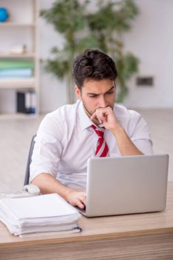 Ofisteki aşırı işten memnun olmayan genç bir çalışan.