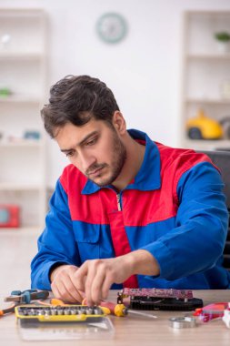 Laboratuvarda bilgisayar tamir eden genç bir tamirci.